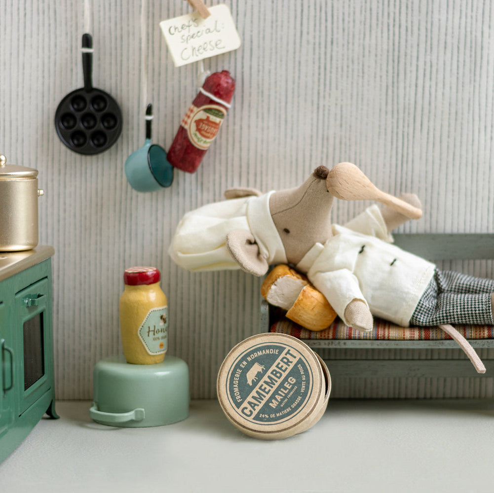 Toy rabbit lying on a bench in a kitchen setting with various items around