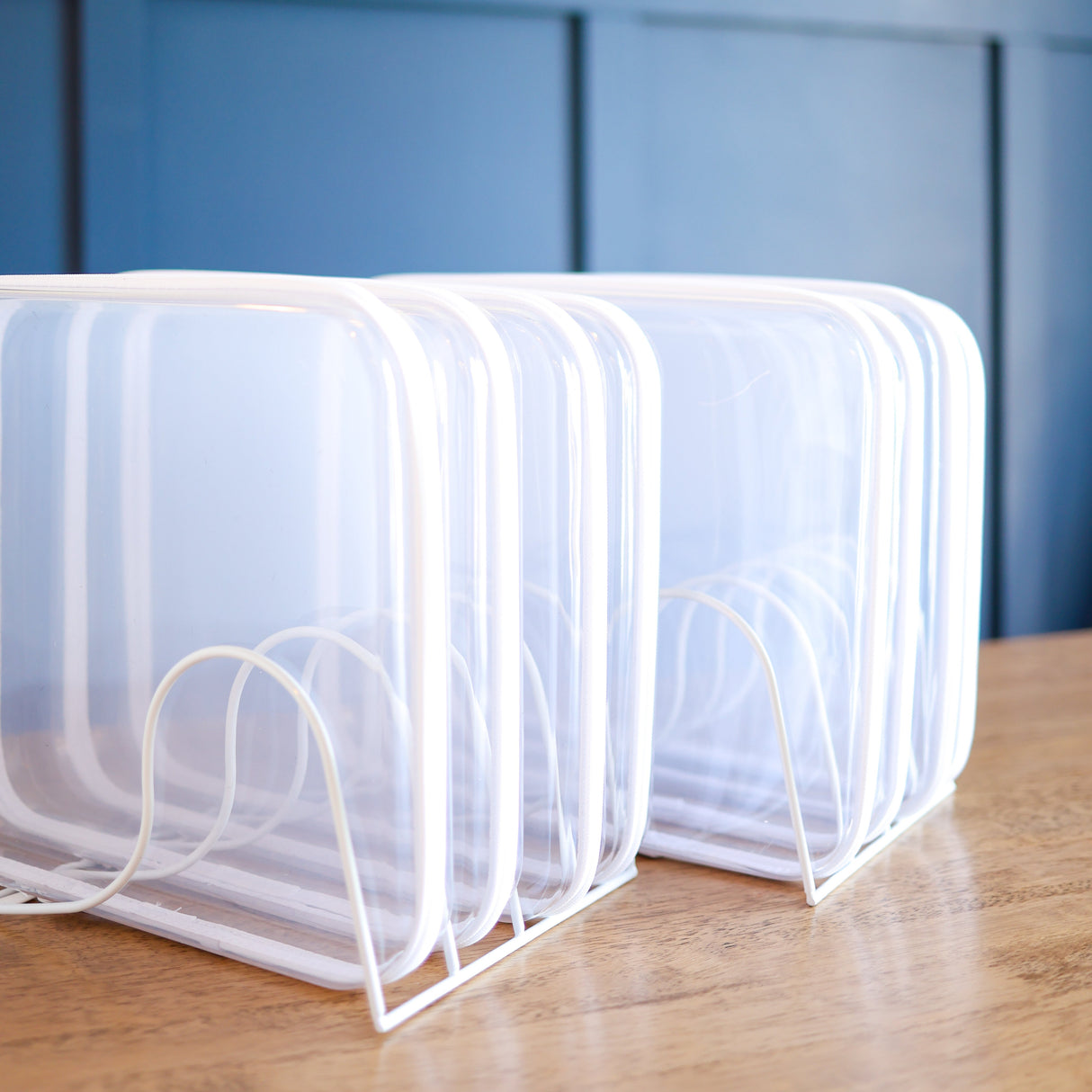 White rack holder on a wooden surface with a blue wall in the background