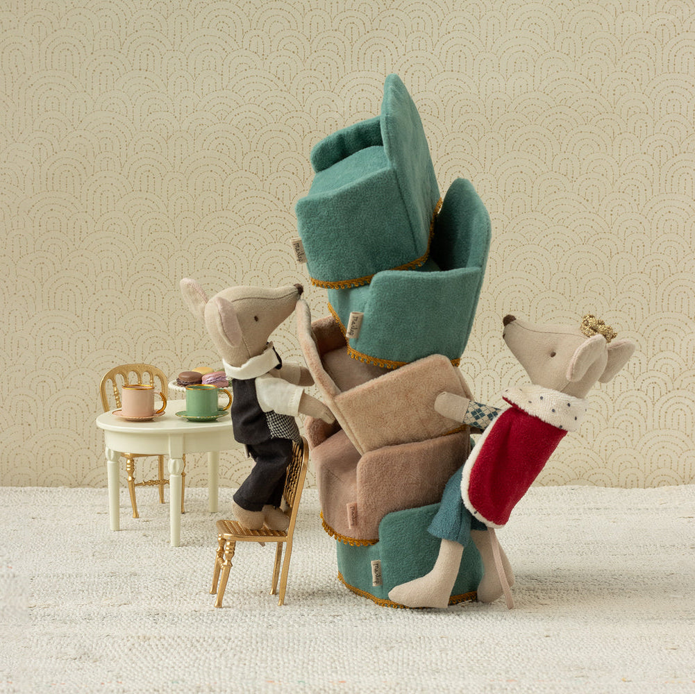 Stack of plush chairs with animal figures on a neutral background