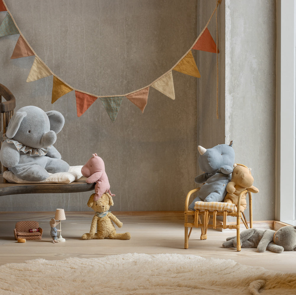 Children's room with plush toys and a colorful banner on a wall.