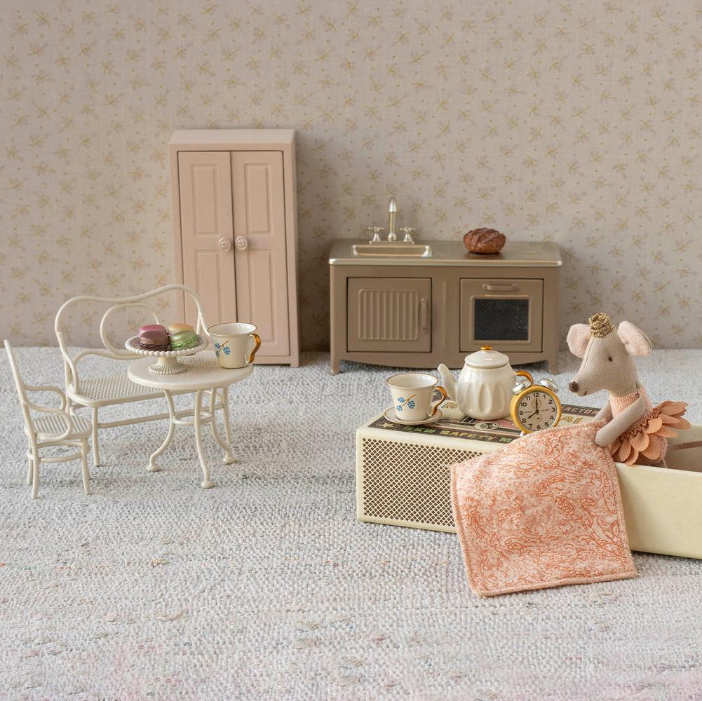 Miniature dollhouse furniture set with a toy mouse and accessories on a neutral background