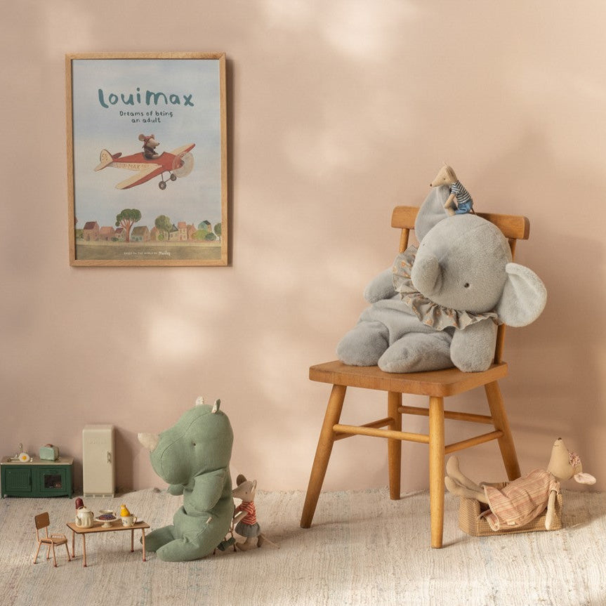 Children's room with stuffed animals and a poster on a beige wall