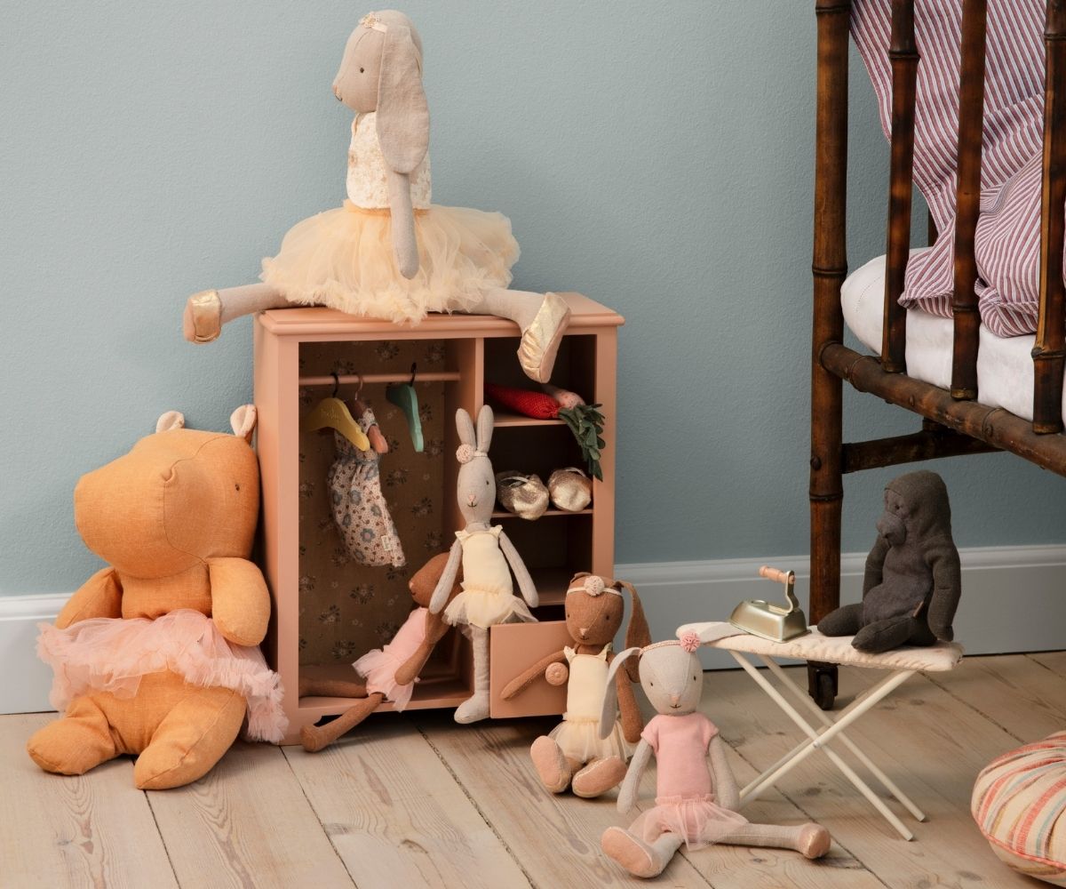 Children's toys and a small wooden cabinet against a light blue wall.