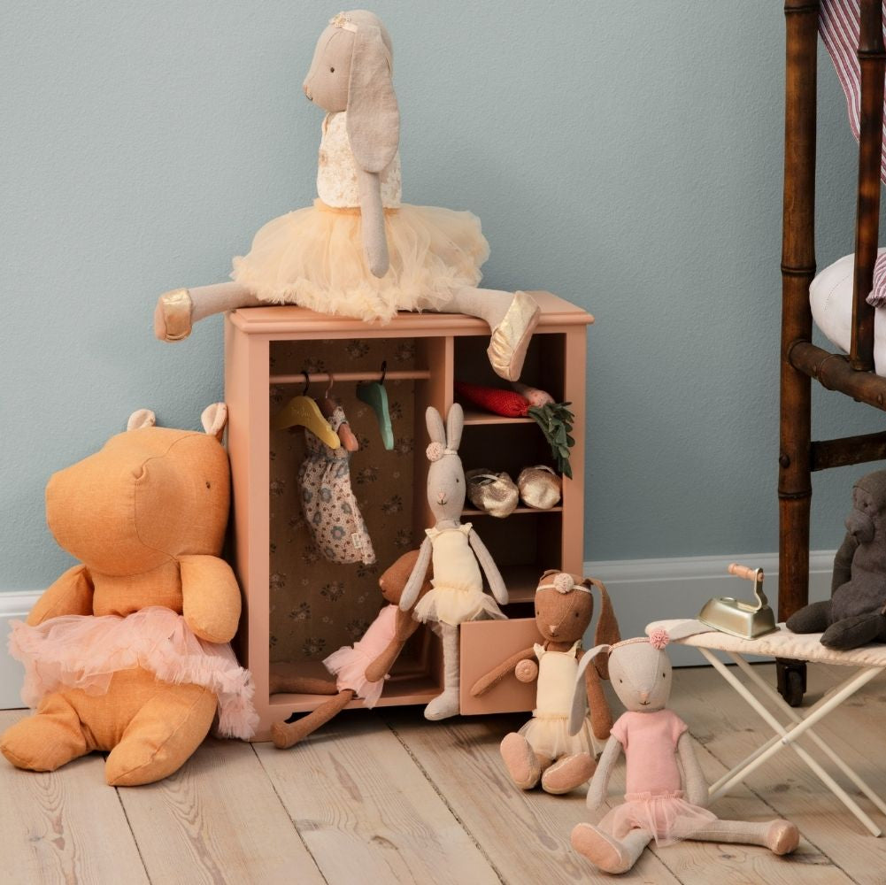 Children's toys and a small wooden cabinet against a light blue wall.
