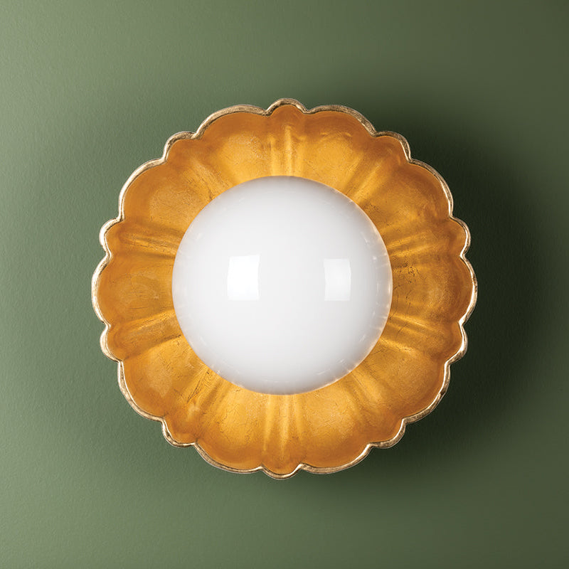 Decorative wall light fixture with gold floral design on a green background