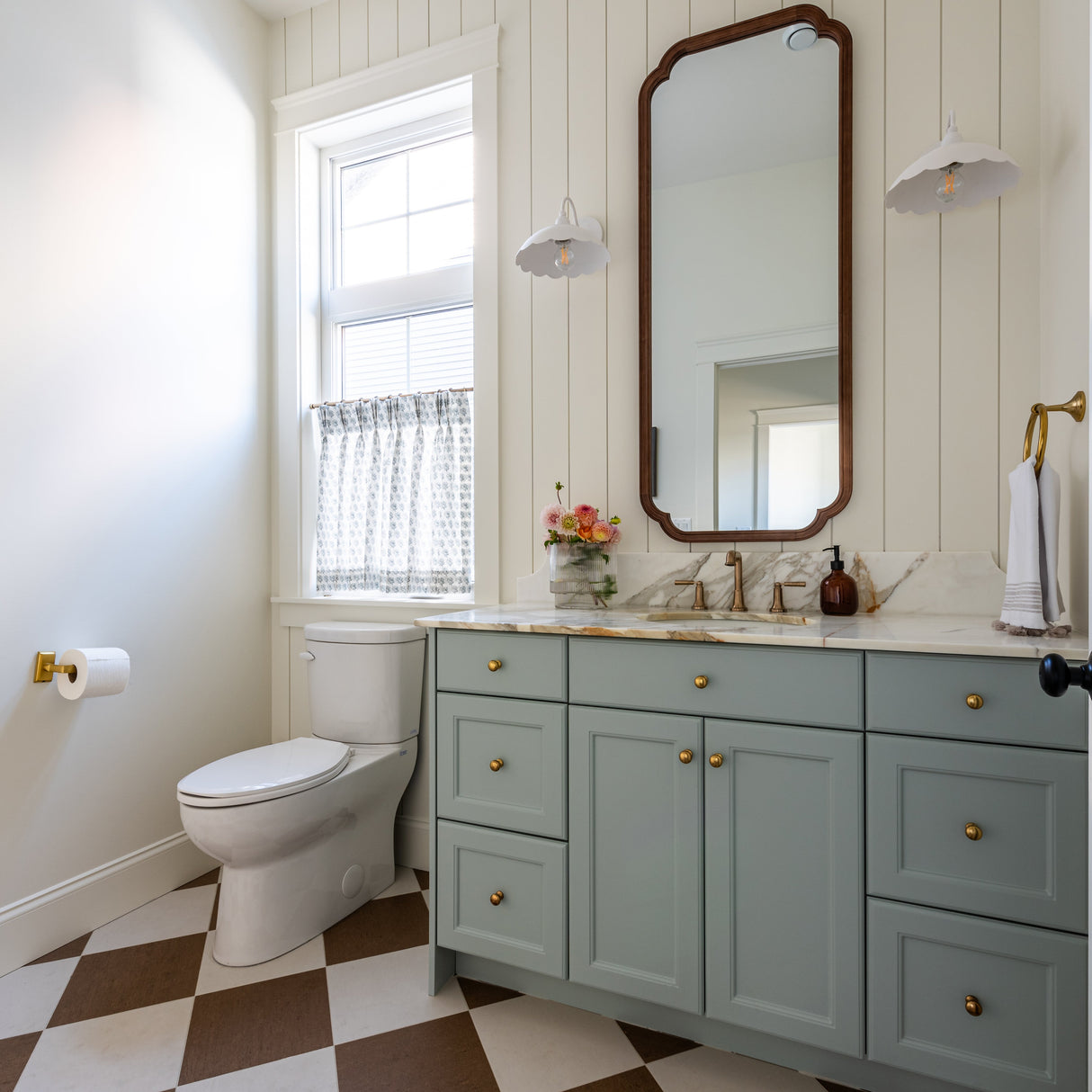 Bathroom with a toilet, sink, and vanity with a large mirror.