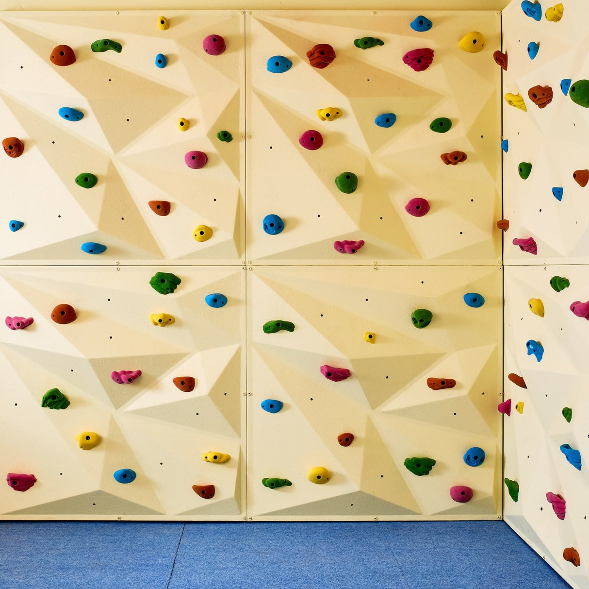 Bouldering wall for kids ages 8–10 with advanced holds and soft crash mats.