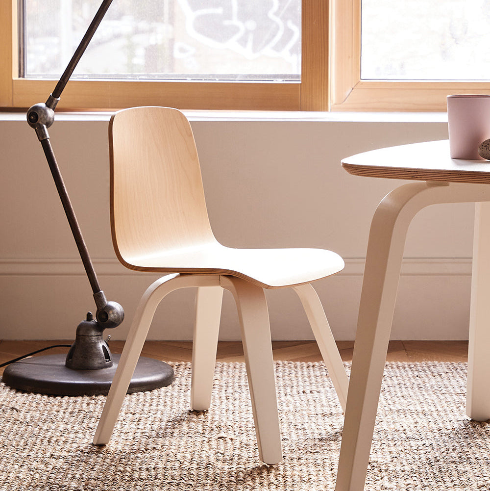Wooden chair and table in a room with a lamp and window