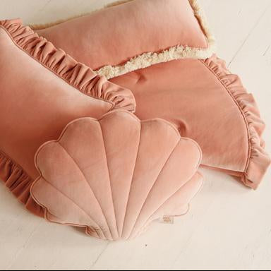 Pink shell-shaped cushions on a light wooden floor