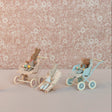Miniature toy figures with strollers against a floral-patterned background