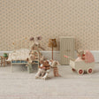 Miniature bedroom scene with toy furniture and animals in a room with floral wallpaper.