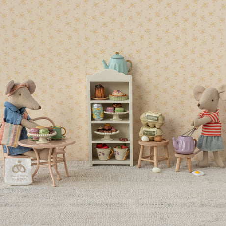 Miniature diorama with toy mice and a tea set against a floral wallpaper background