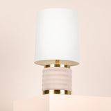Wall-mounted lamp with white shade and gold base on a beige background