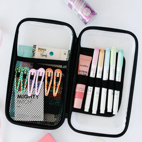 Open pencil case with stationery items including markers and hair clips on a white background