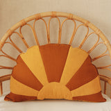 Decorative pillow with sunburst pattern on a wicker chair
