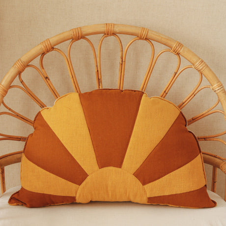 Decorative pillow with sunburst pattern on a wicker chair