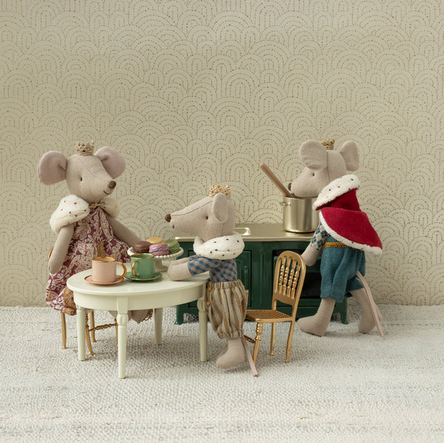 Four toy mice with human-like clothing and accessories in a room setting.