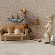 Miniature living room scene with toy mice and furniture against a floral wallpapered wall.