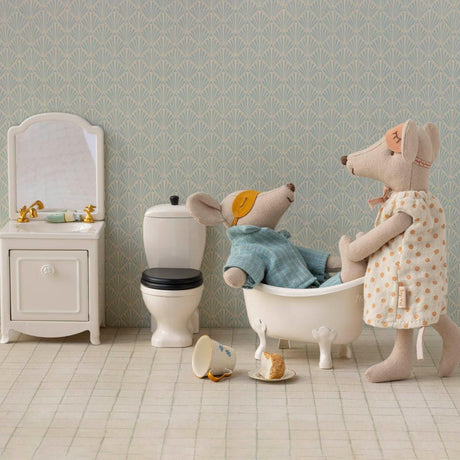 Miniature bathroom set with toys including a bathtub and toilet.