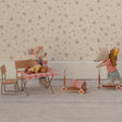 Two toy mice with a small table and chairs on a patterned floor.