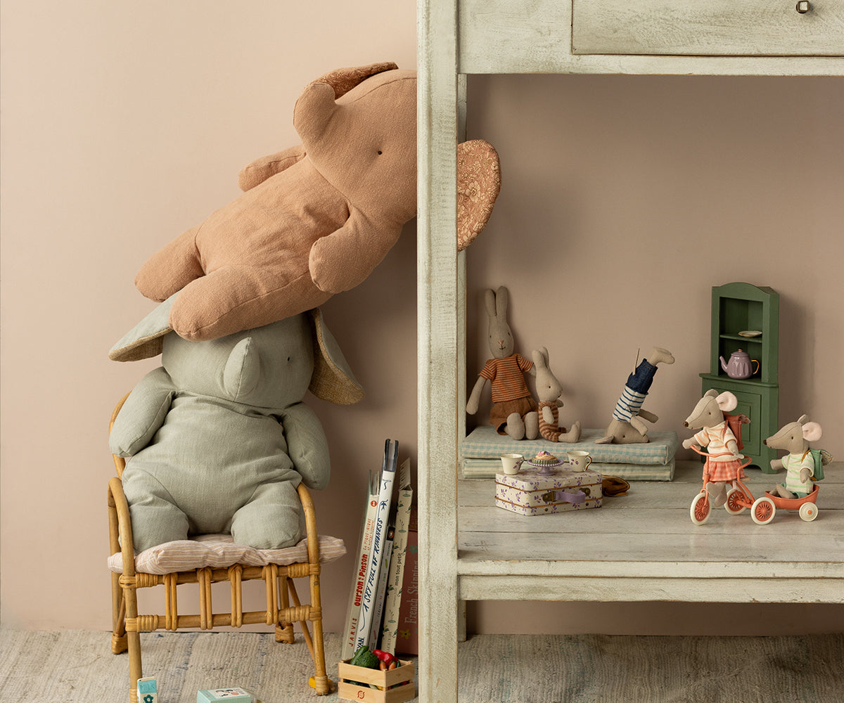 Children's room with stuffed animals, books, and toys on a shelf.
