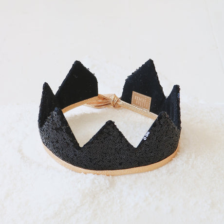 Black sequins crown with white bow on a light background