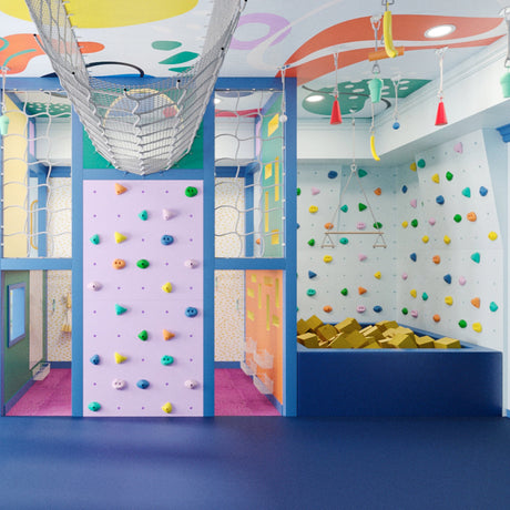 Colorful indoor playroom with climbing wall and slide