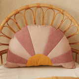 Decorative pillow with a sunset pattern on a wicker chair.