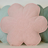 Flower-shaped pink cushion among other floral cushions on a light background