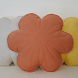 Flower-shaped cushions in orange, gray, and yellow on a white surface.