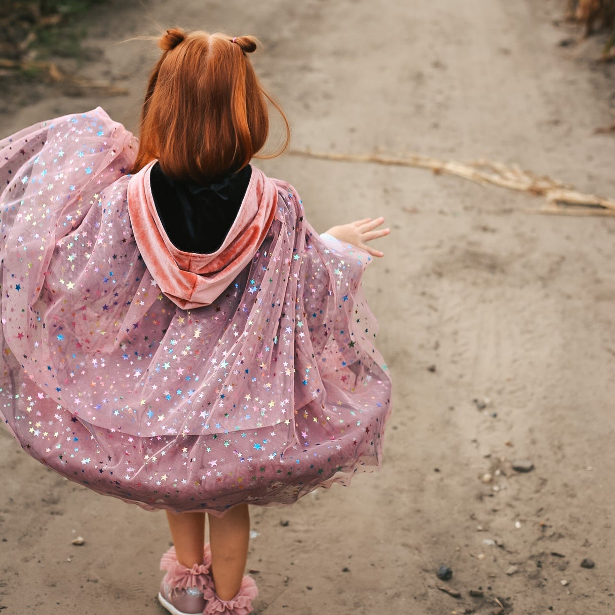Child in cape with rainbow stars