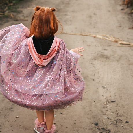 Child in cape with rainbow stars