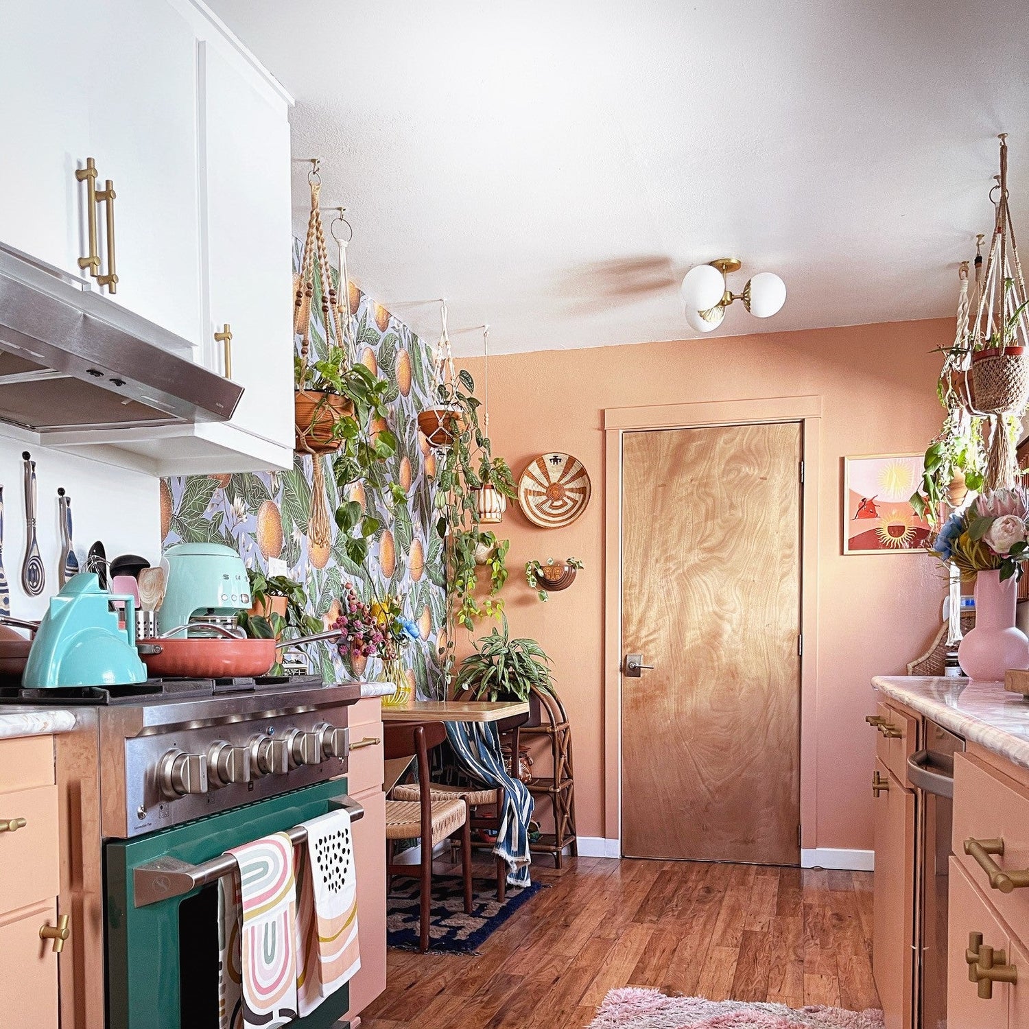 Kitchen with green oven, pink cabinets, and a Christmas tree.