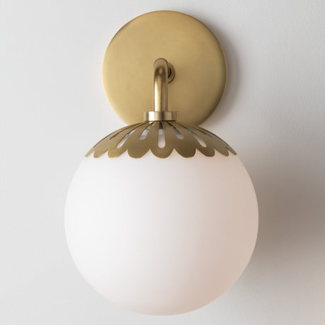 Wall-mounted light fixture with gold decorative shade and white glass on a plain background