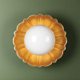 Decorative wall light fixture with gold floral design on a green background