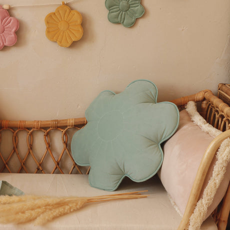 Decorative flower-shaped pillows and a banner with colorful flowers on a neutral background.