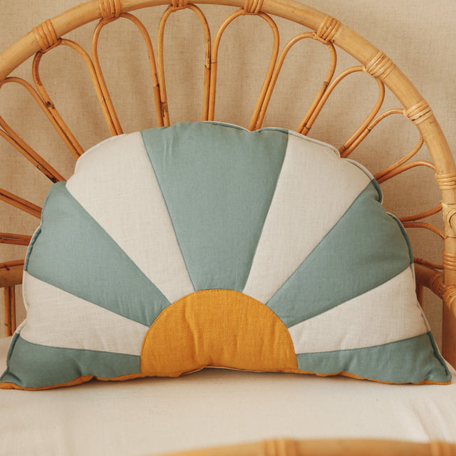 Decorative pillow with sunburst pattern on a wicker chair
