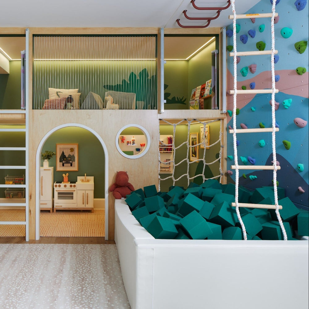 Children's playroom with climbing wall, loft bed, and colorful decor.