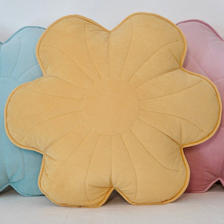 Flower-shaped cushions in yellow, blue, and pink on a white surface.