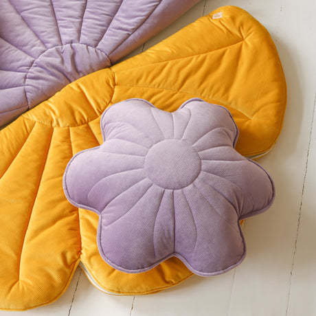 Flower-shaped cushions in purple and yellow on a white floor.
