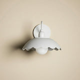 White wall light fixture on a beige wall with floral pattern