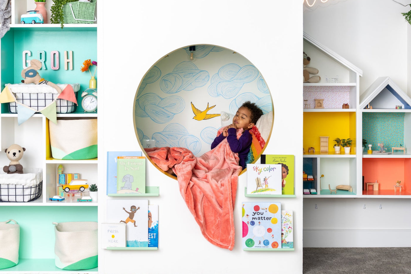 Colorful playroom with reading nook, dollhouse, and built in shelves