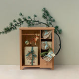 Wooden cabinet with decorative items and Christmas decorations on a light background