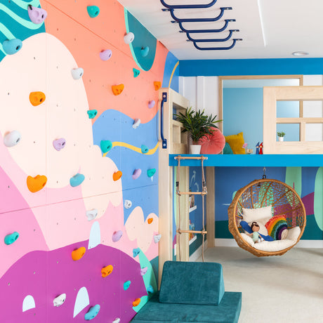 Children's room with colorful walls, a loft bed, and a hanging chair.