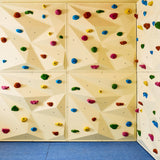 Bouldering wall for kids ages 8–10 with advanced holds and soft crash mats.