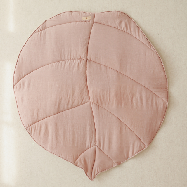 Pink leaf-shaped cushion on a beige background