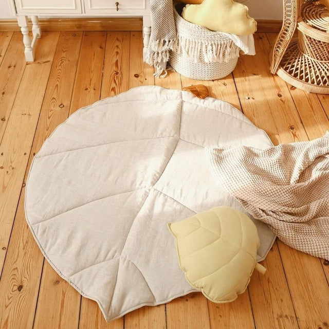 Children's room with a round white rug, toys, and a wicker chair.