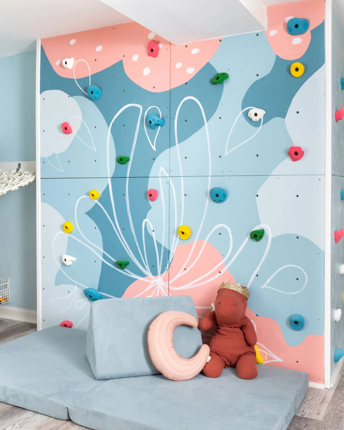Compact playroom with a beginner climbing wall and soft crash mat for small spaces.