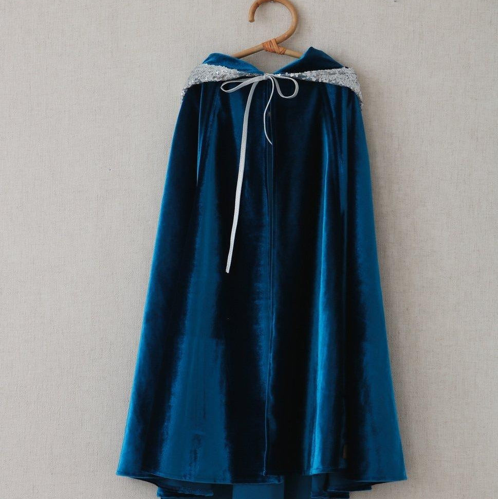 Blue velvet cape with white trim on a wooden hanger against a plain background