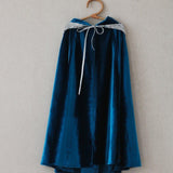 Blue velvet cape with white trim on a wooden hanger against a plain background